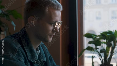 Young male freelancer working on the project in the cafe having videocall. High quality 4k footage