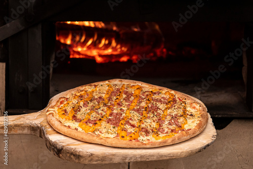 Brazilian style pizza entering the wood oven