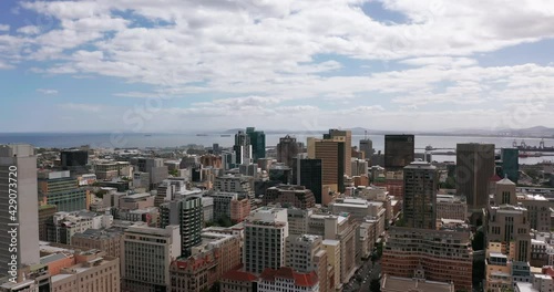 Wide aerial shot tracking forward into the city of Cape Town during a spectacular sunset with Table Mountain in the background.