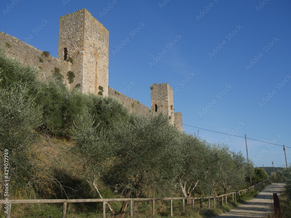 walkway that goes around the city walls with circular perimeter with towers and surrounded by the countryside and olive groves