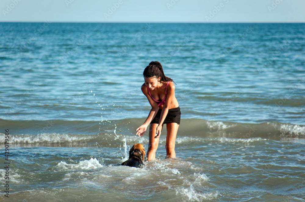 Happy girl playing with a dog on the beach Happy girl playing with a dog on the beach