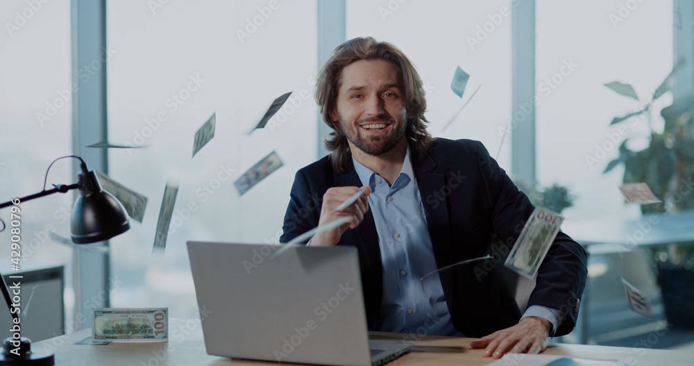 Indoor Portrait of Successful Office Worker Young Businessman throwing Money Rain of Dollars Smiling Celebrating Payday Salary. Indoor Portrait of Successful Office Worker Young Businessman throwing Money Rain of Dollars Smiling Celebrating Payday Salary.