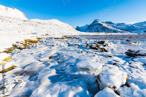 Winterlandschaft mit schneebedecktem Ufer an einem See auf den Lofoten, Norwegen photo