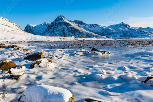 Winterlandschaft mit schneebedecktem Ufer an einem See auf den Lofoten, Norwegen photo