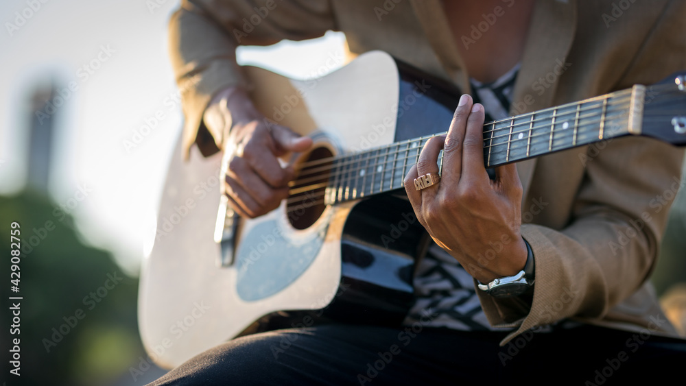 Close up of Latin man playing guitar on the street during sunset