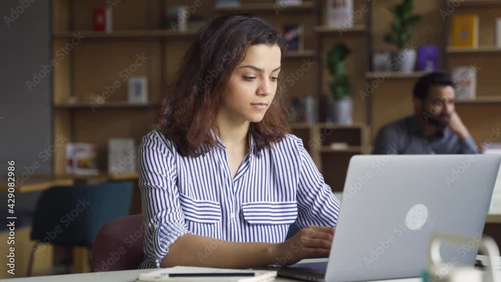 Hispanic latin girl college student using laptop computer watching distance online learning seminar class, remote university webinar or having virtual classroom meeting in university creative space.