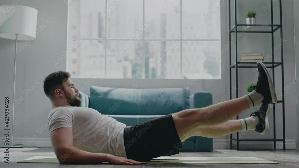 Muscular athlete with beard practices flutter kicks exercise
