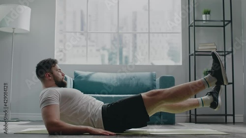 Muscular athlete with beard practices flutter kicks exercise