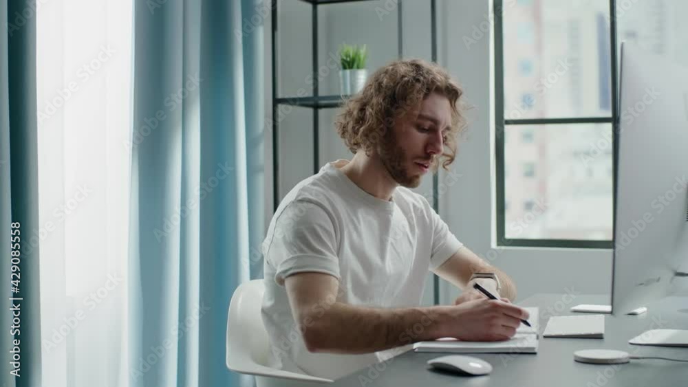 Blond designer turns notebook pages and writes down ideas Blond designer turns notebook pages and writes down ideas