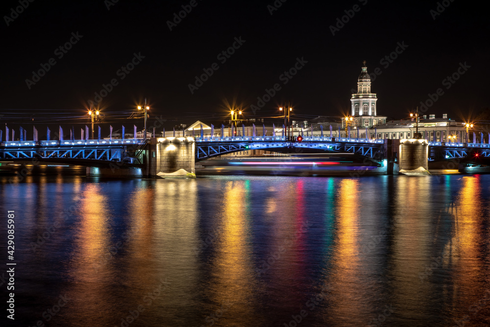 Laying bridges in St. Petersburg. Night city of Russia. Neva River. Reflection of colored lights in the water. Long-term exposure.
