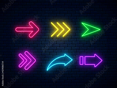 Set of colorful neon arrows, web icons. Neon arrow signs collection. Bright arrow pointer symbols on brick wall background. Banner design, bright advertising signboard elements. Vector illustration.