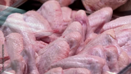 raw chicken wings in butcher shop, closeup in refr photo