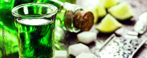 doses of absinthe with sugar cubes. Absinthe bottle, green distilled drink photo