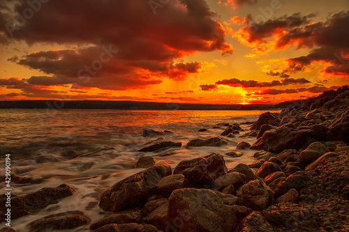 Sunning long exposure sunset over the sea with a rocky beach.