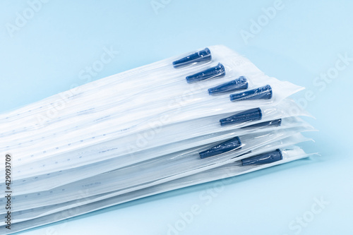 Rusch male and female all purpose catheter on blue background, straight tipped intermittent catheters designed for a single use, packaged individually and sterile, 8 inch photo