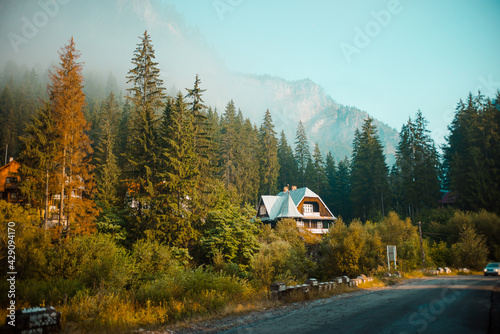 View of old houses in mountain valley in summer. Beautiful landscape with old small village in mountain valley on morning. Mountain village with picturesque summer slopes, morning light.
