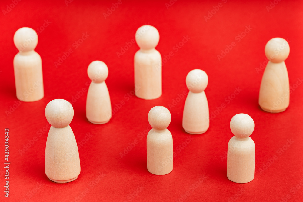 Wooden people figures stand on red backdrop. Society behavior, social distancing during pandemic. Business, teamwork, team diversity metaphor. Relationship, communication problems between people Wooden people figures stand on red backdrop. Society behavior, social distancing during pandemic. Business, teamwork, team diversity metaphor. Relationship, communication problems between people