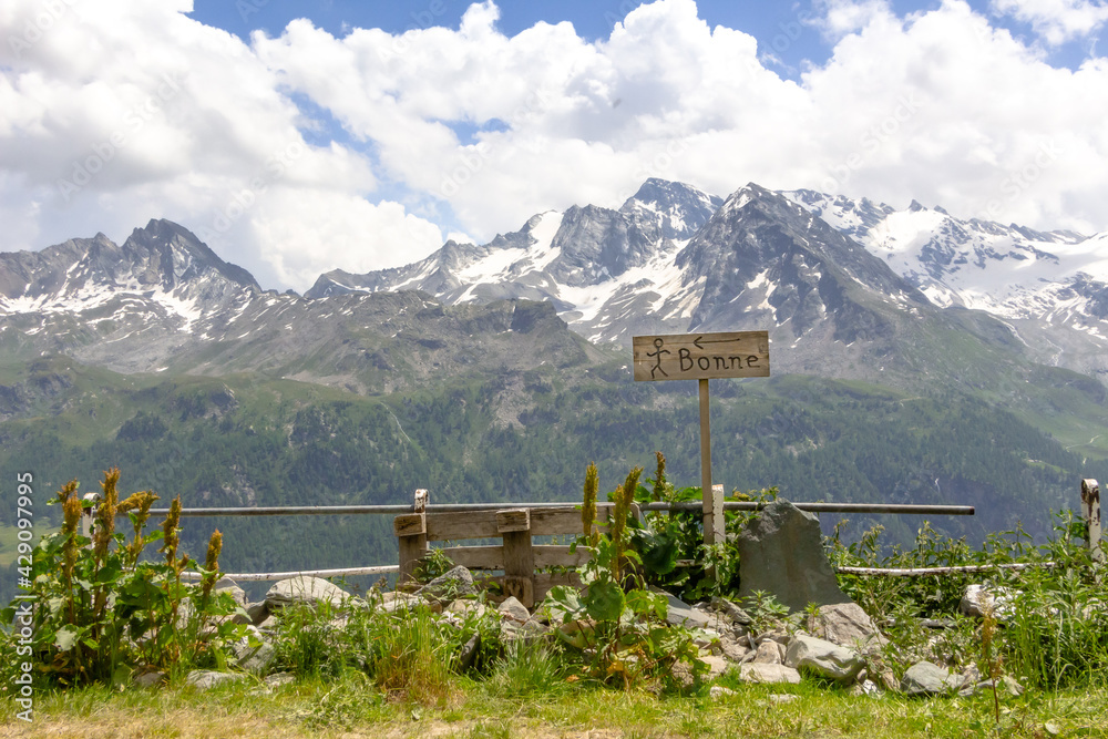 Indicazione del percorso escursionistico per il villaggio di Bonne con paesaggio delle montagne della Valgrisenche. Estate.  Alpi italiane. Valle d'Aosta. Italia