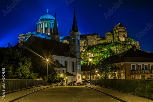 Night view of a narrow street in the hungarian city Esztergom with the church of saint Ignac and basilica on top of the hill. photo