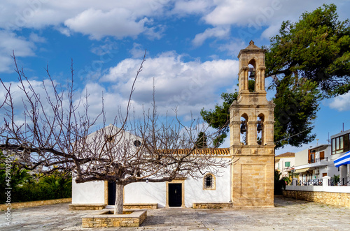 Archanes, Crete Island, Greece. Facade view of the Venetian church of Virgin Mary (Panagia Kera or Faneromeni) in Archanes town. Sunny day, cloudy blue sky photo