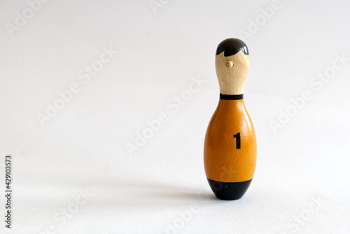 фотографія a wooden puppet in the shape of a bowling pin with a number one shirt