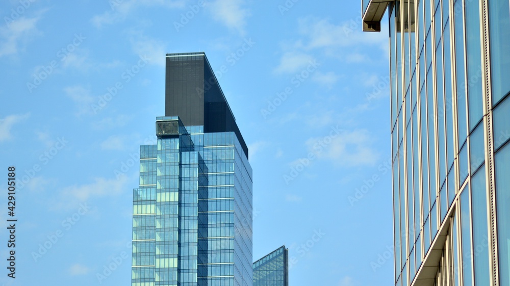 The glazed facade of an office building with reflected sky. Modern architecture buildings exterior background. Clouds sky reflection. The glazed facade of an office building with reflected sky. Modern architecture buildings exterior background. Clouds sky reflection.