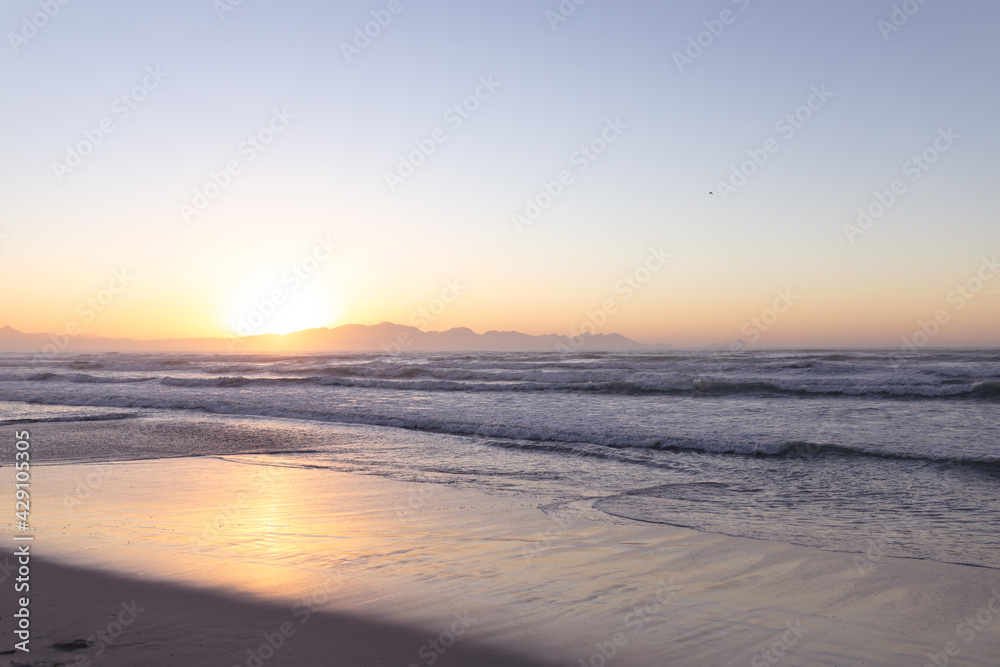 Beautiful view of landscape with beach sea and waves during sunset