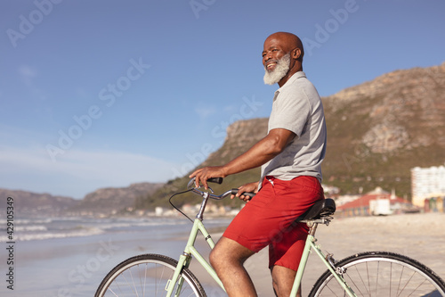 Senior african american man sitting on bicycle smiling on the beach © WavebreakMediaMicro