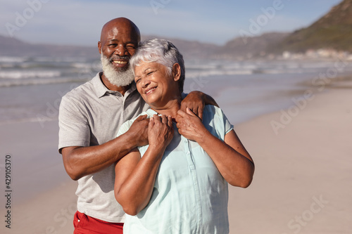Happy senior african american couple embracing each other on the beach