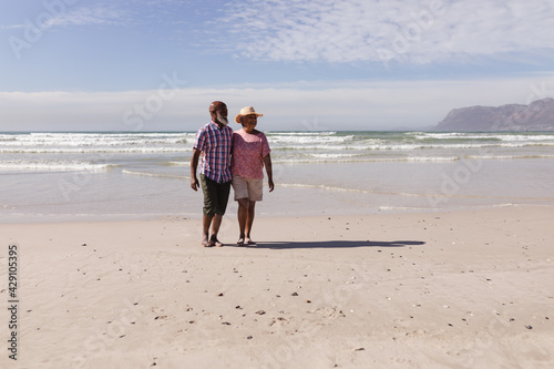 Happy senior african american couple walking together on the beach