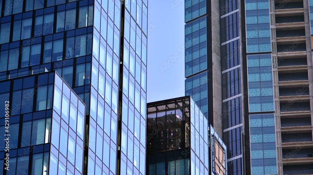 The glazed facade of an office building with reflected sky. Modern architecture buildings exterior background. Clouds sky reflection. The glazed facade of an office building with reflected sky. Modern architecture buildings exterior background. Clouds sky reflection.