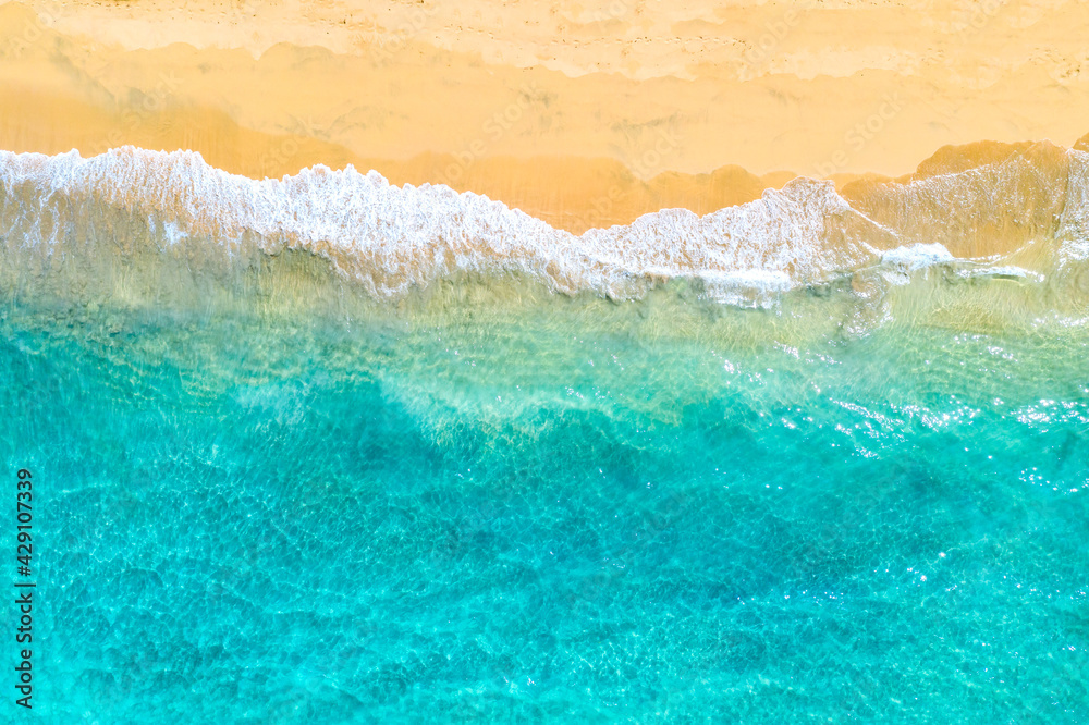 Vacation travel background. Top view aerial drone photo of ocean seashore with beautiful turquoise water and foam sea waves. Caribbean resort.