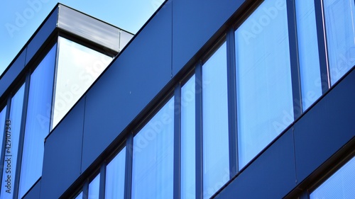 The glazed facade of an office building with reflected sky. Modern architecture buildings exterior background. Clouds sky reflection.