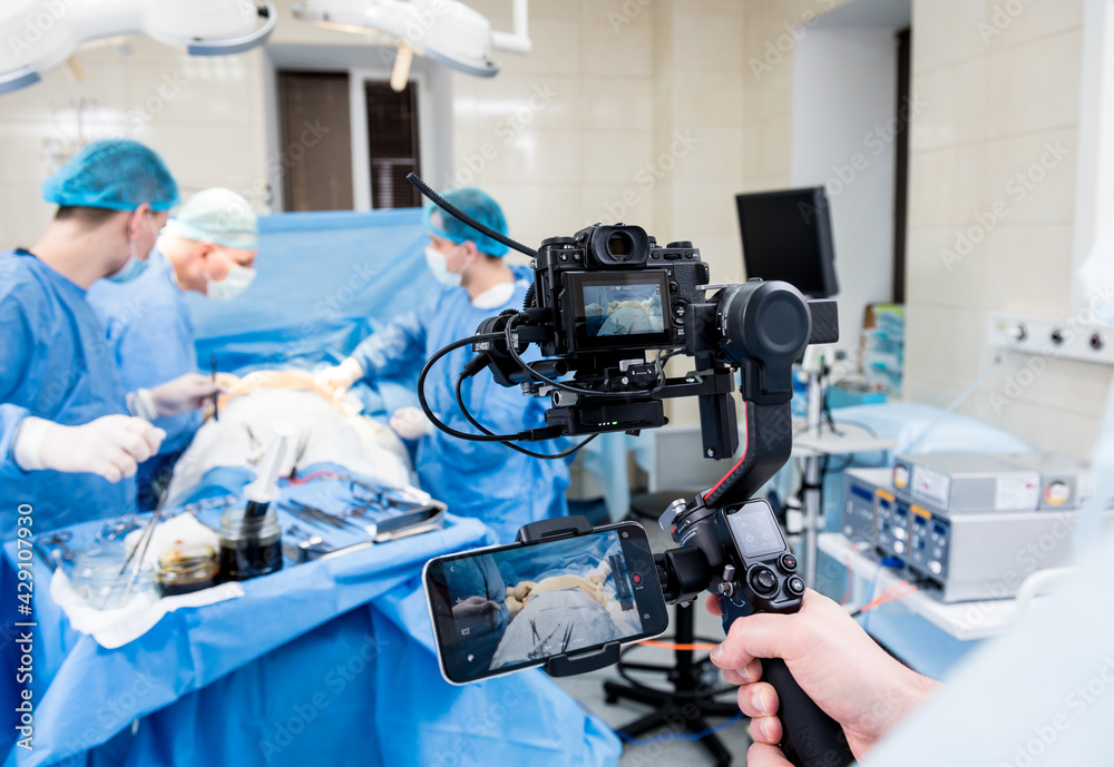 The videographer shoot the surgeon and assistants in the operating room with surgical equipment The videographer shoot the surgeon and assistants in the operating room with surgical equipment