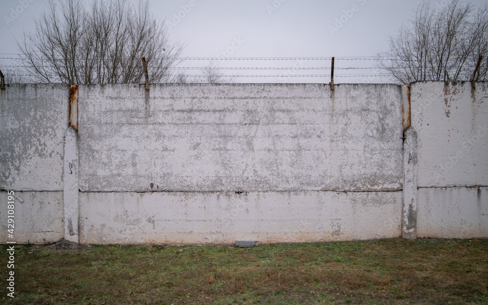 Wall with barbed wire fence, the concept of prison, salvation, Refugee,  lonely. With space for text. Photos | Adobe Stock