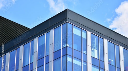 The glazed facade of an office building with reflected sky. Modern architecture buildings exterior background. Clouds sky reflection.