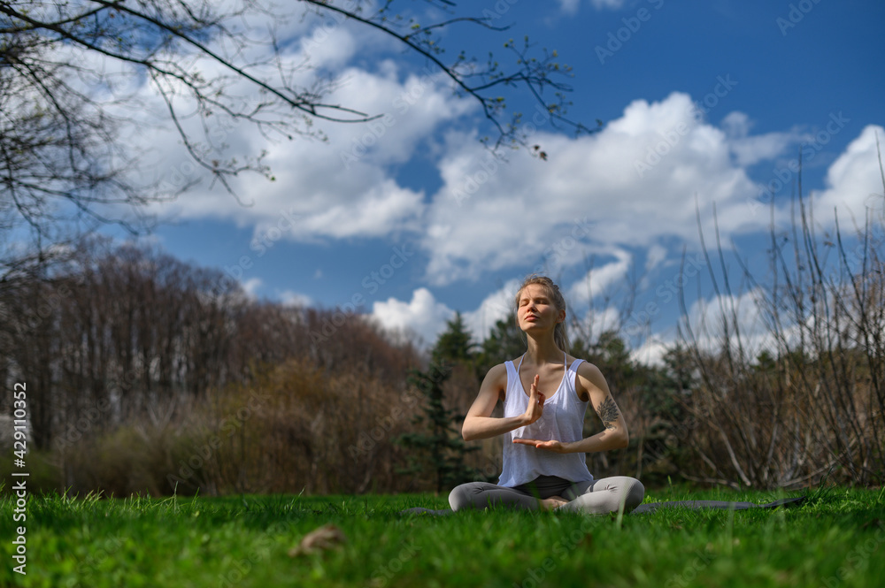 Yoga practice and meditation outdoor. Girl in the park