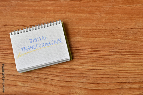 A small sketchbook labeled Digital Transformation sits on the table.