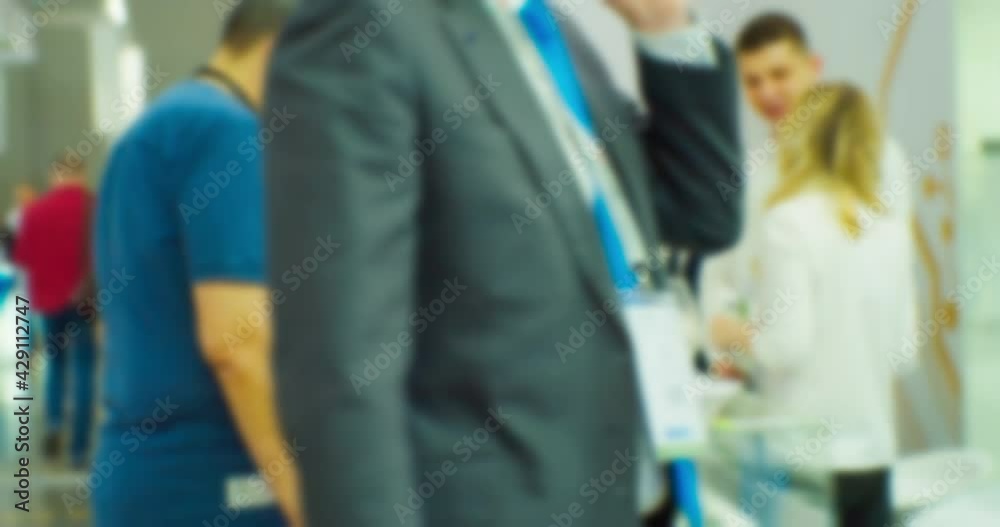 Many people inside a large bright hall inside the business center.Blurred background on a business theme. Many people inside a large bright hall inside the business center.Blurred background on a business theme.