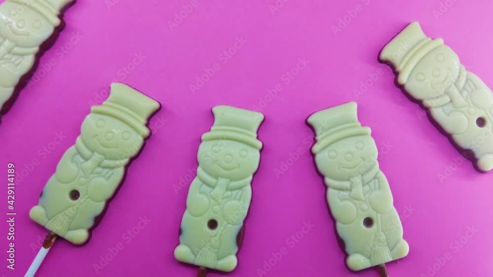 Funny chocolate snowman candy on color background Funny chocolate snowman candy on color background