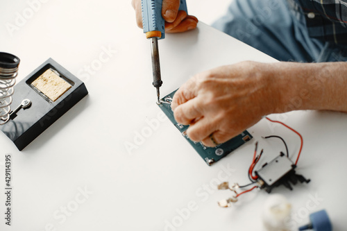 Male tech repairs electronic equipment at home