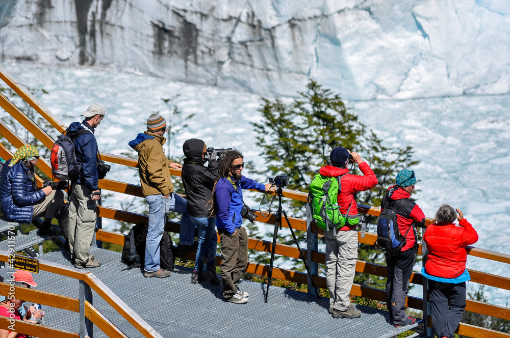 group of tourists taking photos of perito moreno glacier arid region country