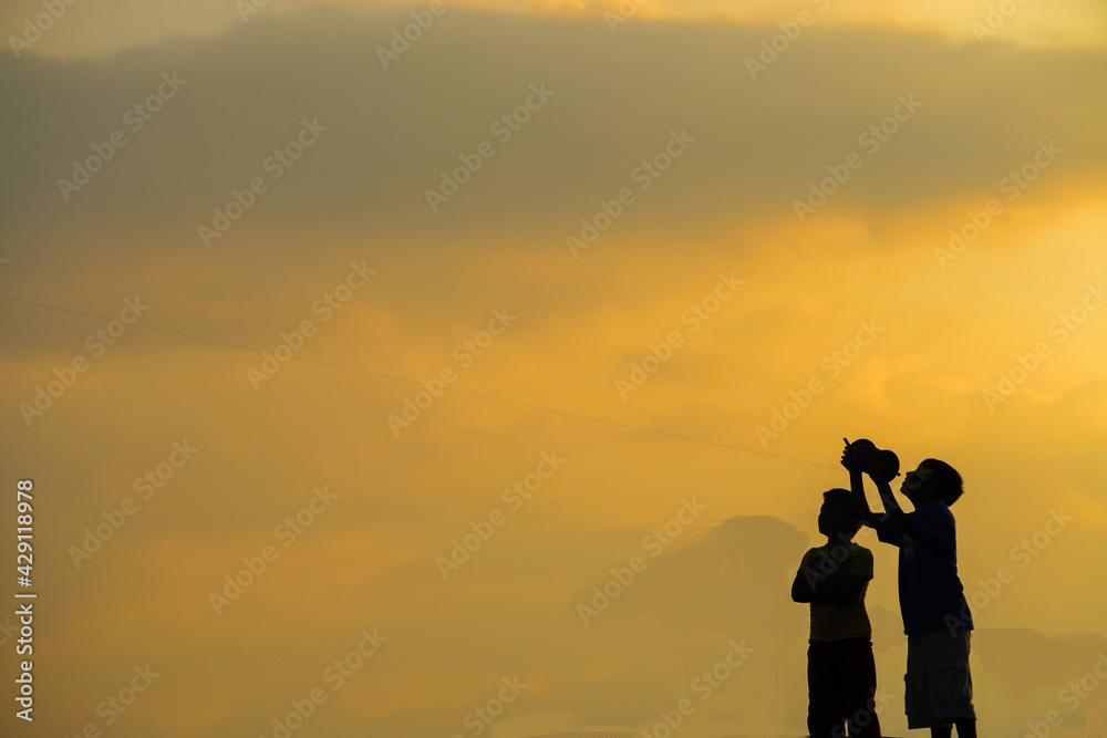 Two boys flying kite.