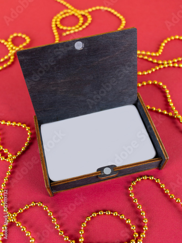 Board game, cards in a gift wooden box. On a red background with gold beads
