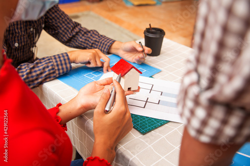 Architects engineer discussing at the table with blueprint - Closeup on hands and project print.