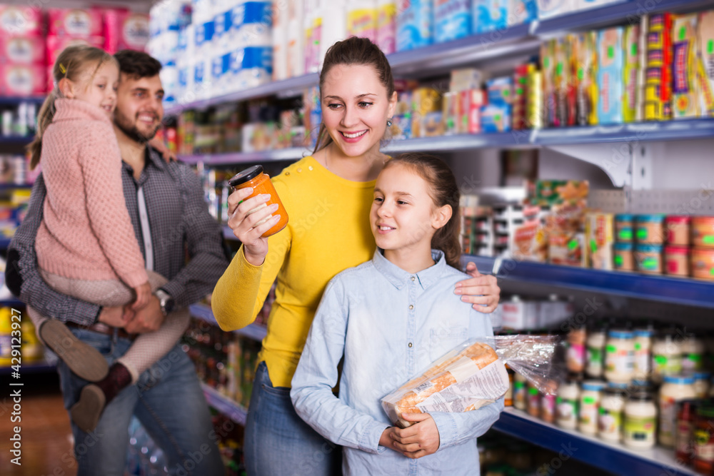 happy family of four shopping together in grocery store