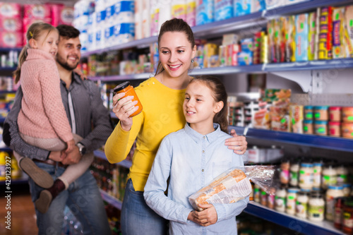 happy family of four shopping together in grocery store