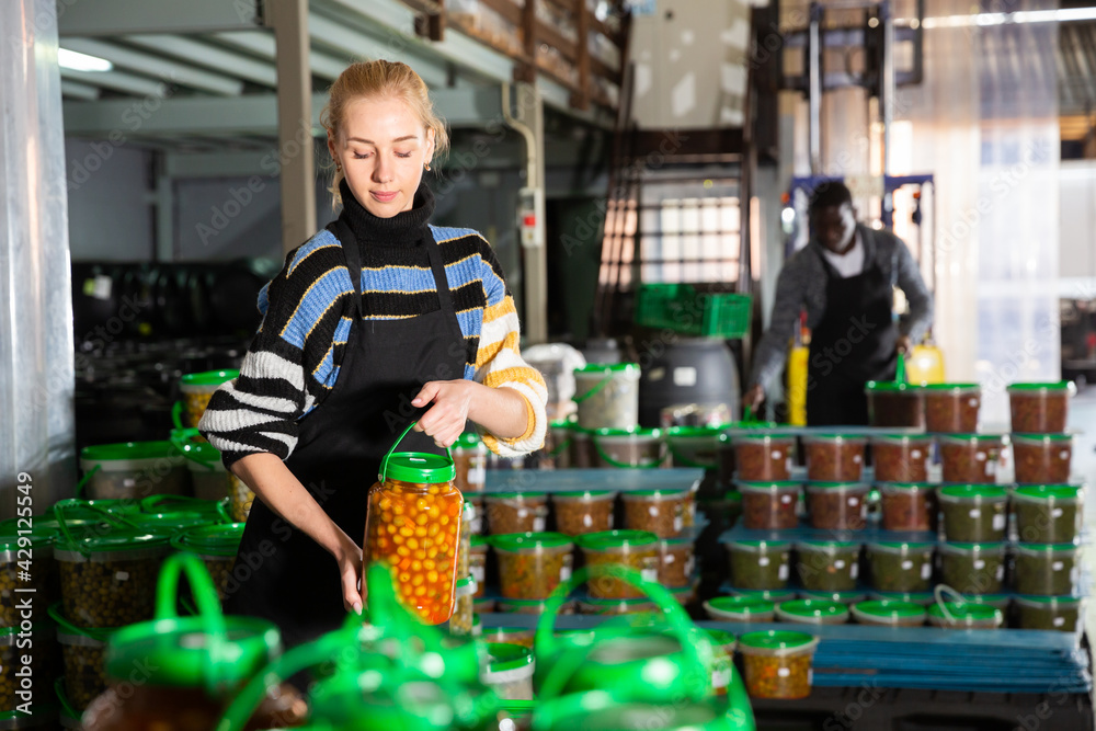 Workwoman carrying plastic containers with ripe olives. High quality photo