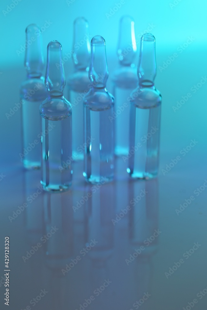 Ampoules with solution for injection. Medicine and
Pharmacology.Biotechnology and Science.Glass transparent ampoules on a blue blurred background.Health and beauty.Organic natural cosmetics Ampoules with solution for injection. Medicine and
Pharmacology.Biotechnology and Science.Glass transparent ampoules on a blue blurred background.Health and beauty.Organic natural cosmetics