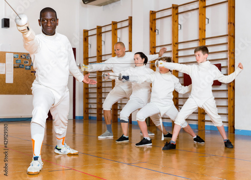 African American happy cheerful fencer practicing effective fencing techniques in training room
